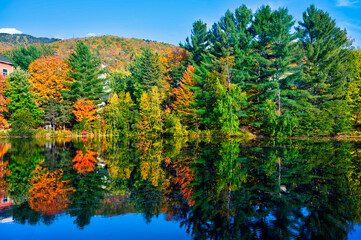 Scenic autumn view of colorful trees reflecting on a calm lake at Mont-Tremblant, Quebec. Vibrant...