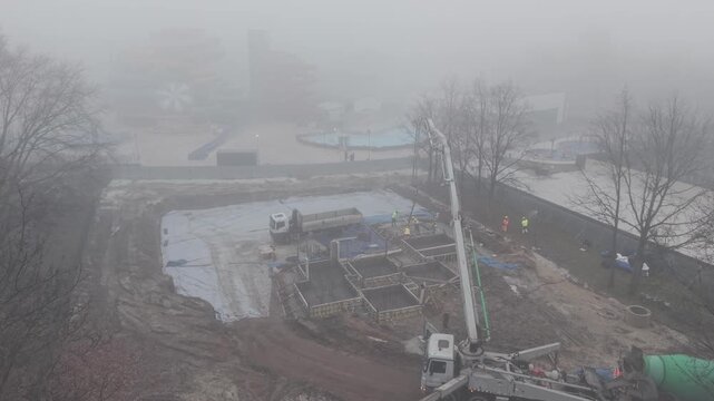 Wylewanie betonu na budowie, widok z drona podczas lekkiej mgły