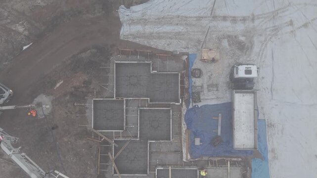 Wylewanie betonu na budowie, widok z drona podczas lekkiej mgły