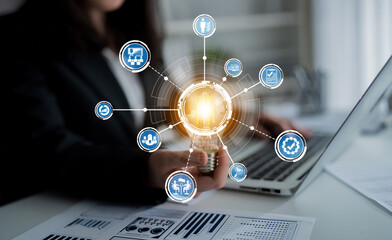 A business professional engages with a laptop while surrounded by digital network icons, showcasing the integration of technology and analysis in a modern office environment. Crux