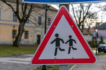 Warning sign for children playing near street in residential area during late afternoon