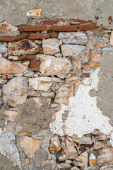 Wall made of stones and bricks with a mix of mortar seen during daylight hours in an urban area