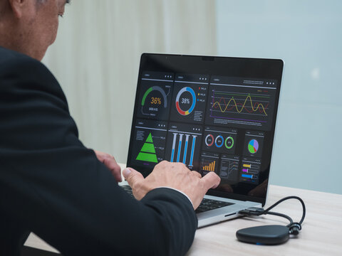 business man in suit analyzing charts and graphs on laptop screen in office setting. image show data visualization such as pie chart and bar graph, representing business analytics and decision-making. - Powered by Adobe