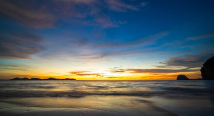 serene panorama image capture beauty sunset over calm ocean. sun low on horizon casting warm golden glow across sky and reflect off gentle wave. warm orange near creating peaceful calm atmosphere.