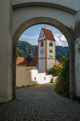 Scenic View of St Mang Basilica Tower through Stone Arch in Fussen, Germany