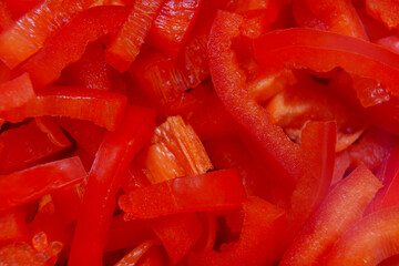 Chopped red bell peppers on a cutting board in a kitchen setting
