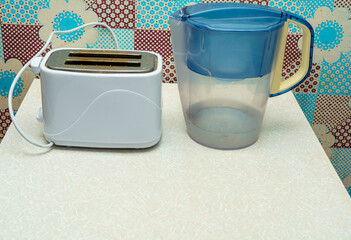 Kitchen scene with toaster and water pitcher on table in a decorated room