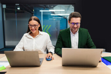 Graphic designers businesspeople working in office with laptops, working with new ideas in advertising agency, sitting in board room in office