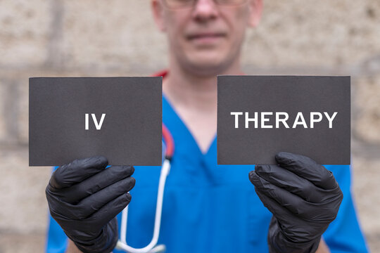 Intravenous vitamins, supplements, minerals infusion therapy medical concept. Doctor holding black cards sees the text IV THERAPY. IV Drip Therapy for Medical Wellness.