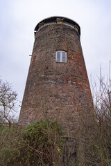 Old, historic and disused drainage mill on the river bank of the River Bure, Norfolk Broads