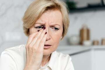 Woman with blurred vision shows concern about her tired eyes and health issues