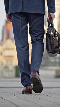 Senior businessman with bag walks to office building