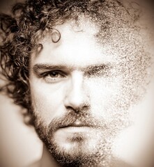 Obraz premium Artistic Reflection: A captivating portrait of a man, split in two, one side in sharp focus and the other subtly fading into a cloud of particles.