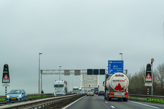 Netherland - November 28 2025: Dutch Highway Traffic with Trucks and Road Signs on the A27 Motorway Near Gorinchem and Gorinchem-Vesting Heading Towards Merwedebrug Bridge