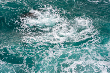 Swirling sea foam on turquoise water