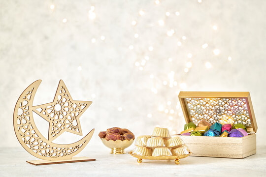 Ramadan kareem background . Crescent moon decor decor with dates , maamoul semolina cookies and chocolate candy