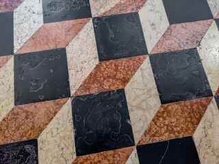 Colourful marble floor in ancient church with white, orange and black tiles