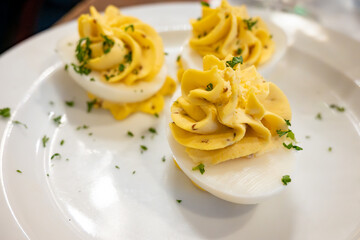 Traditional french boiled eggs mimosa stuffed with yolk, mayonnaise and herbe, served in bouillon bistro restaurant in Paris