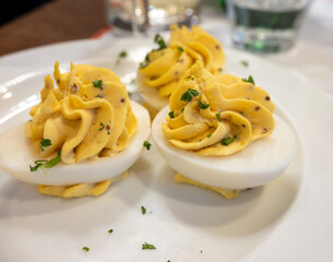 Traditional french boiled eggs mimosa stuffed with yolk, mayonnaise and herbe, served in bouillon bistro restaurant in Paris