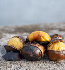 Traditional vintage French equipment for roasting and grilling fresh chestnuts over open fire, delicious street food, eating nuts on streets of Paris in autumn