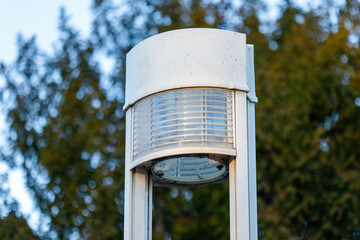Modern street lamp illuminating park at daytime
