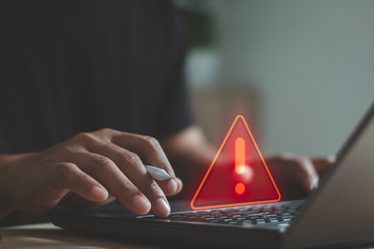 Cyber security warning concept with person typing on laptop, showing alert symbol and data risk notification. Cybersecurity, system error, data protection, hacking prevention, IT security services.