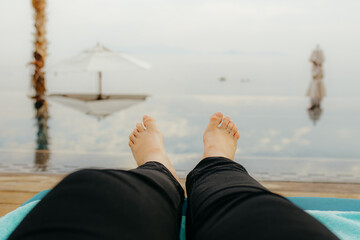 Bare Feet Relaxing by Infinity Pool