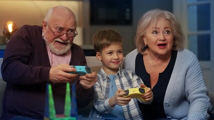 Happy boy and grandparents playing video games with controllers, home pastime