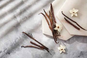 Composition with vanilla sticks, flowers and boards on grunge background