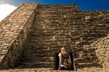 Tourist woman entering an ancient Ehecatl Quetzalcoatl temple in Calixtlahuaca, Mexico