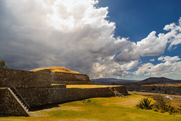 Ancient Tlaloc temple pyramid ruins under dramatic stormy sky in Calixtlahuaca, Mexico