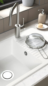 Modern kitchen sink setup with a strainer and soap dispenser near a window and plant.