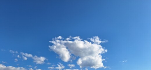 Beautiful bright blue sky with white fluffy clouds on sunny day