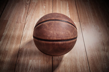 Vintage basketball on a wooden court background in the spotlight