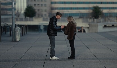 A young couple is arguing outdoors in Paris France showcasing relationship problems and communication issues. This image can be used to depict urban conflict emotional stress and the challenges of rel