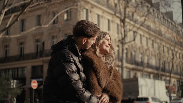 A romantic couple embraces in Paris France showcasing love and affection against a backdrop of classic cityscape architecture The image is suitable for travel lifestyle and relationship themes.