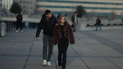 A stylish couple walks together in Paris France showcasing winter fashion and affection The urban setting provides a modern backdrop for their romantic outing.