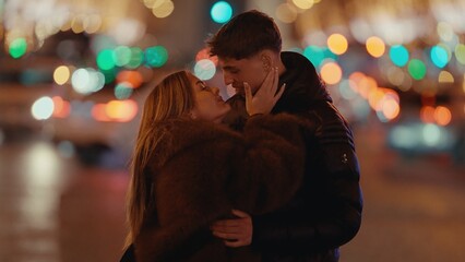 A romantic couple embraces in Paris France at night with bokeh lights in the background. This image conveys love affection and the magic of city romance suitable for travel and lifestyle content.
