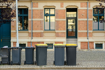 View of brick building and garbage containers on street