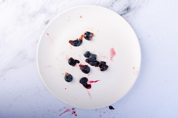 Top view of a plate with crushed blueberries.