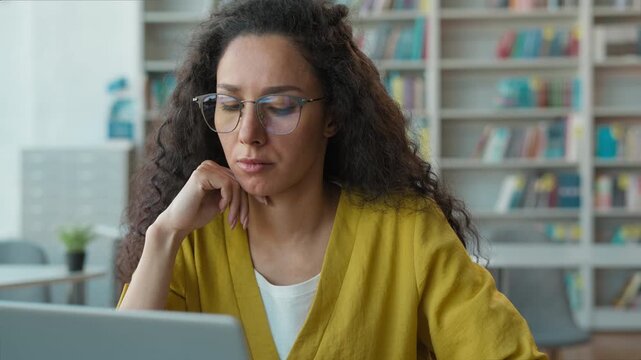 Latina Hispanic woman working typing laptop in university library female girl lady student computer project technology elearning diploma study education contemplation aspirations desktop pc learning