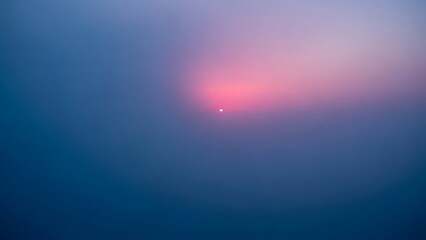 Obraz premium Tranquil sunrise sky with delicate gradients and blurred sunspot