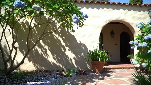 Sunny Mediterranean Courtyard Scene with Archways, Potted Plants, and Blooming Blue Flowers