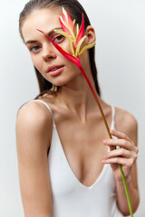 Young woman with flower, expressing beauty and elegance, wearing minimal makeup, against a soft pastel background. Aesthetic, fashion, beauty concept.