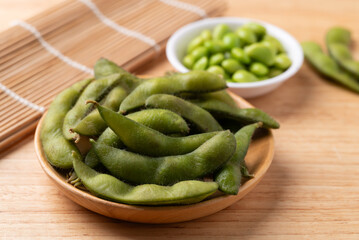 Boiled Edamame beans (Japanese soybeans) on wooden background