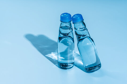 夏の冷涼感が伝わる青と影のビー玉入りガラス瓶のラムネ