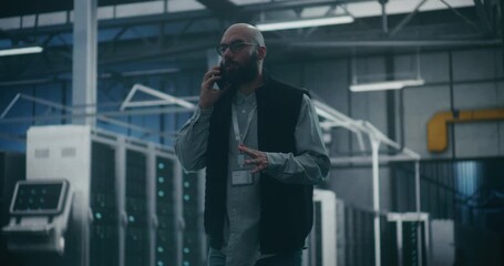 IT Manager Responding Call on Cell Phone. Focused IT Manager Responds Urgent Talks on Cell Phone in Data Center Server Hall. Concept of Rapid Communication, IT Crisis Management, and Responsiveness. - Powered by Adobe