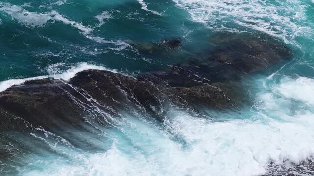 Aerial Drone Shot of Powerful Ocean Waves Breaking Over Dark Coastal Rocks
