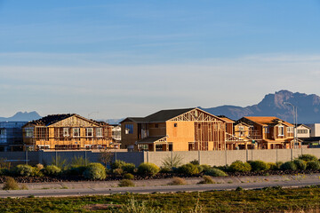 A row of newly built suburban homes with desert landscaping and mountain views, illustrating residential housing development, suburban growth, and planned community real estate