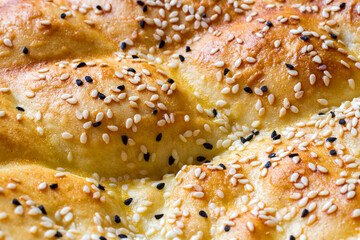 Close-up of the surface of bread cake with sesame seeds. Close-up of fresh, fragrant pastries